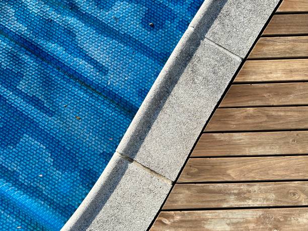 Swimming pool with deck and blue pool cover