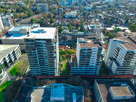 Drone view looking down on Commercial Suburb of Burwood in Sydney residential houses in suburbia suburban house roof tops and streets park NSW Australia