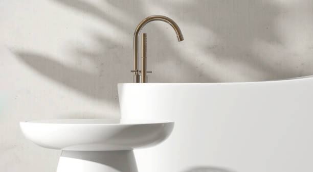 istock White round side table by bathtub in bathroom in sunlight, leaf shadow on white gray cement wall 1602578547