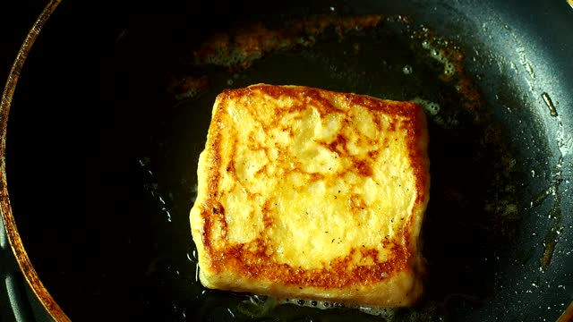 Frying egg and milk bread with butter in pan