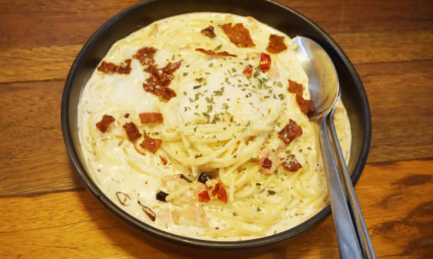 istock Spaghetti carbonara with becon on wooden table 1602614557