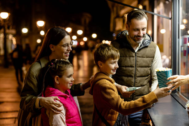istock Parents, Son, and Daughter Share Laughter While Buying Popcorn 1602635604