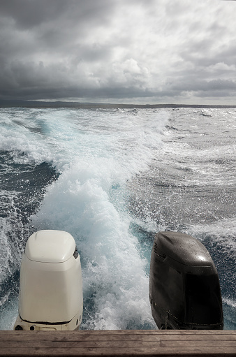 Powerful outboard motor of a speedboat escaping a storm.