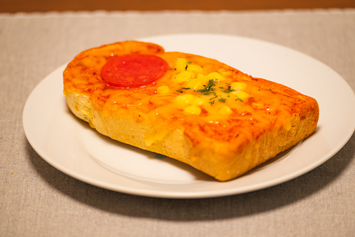 The pizza toast is topped with cheese, corn, and salami. It's a semi-prepared product sold in Japanese supermarkets, and all you need to do is toast it for a few minutes.