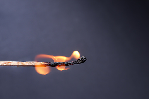 Close up of Burning match on dark background. burning, flaming match on black background.