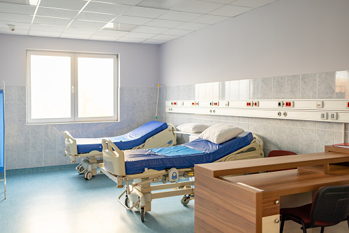 Side view of empty hospital bed in clinic chamber