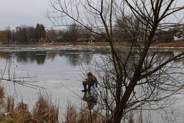 istock Fishermen on the ice, early spring, melting river 1602701159