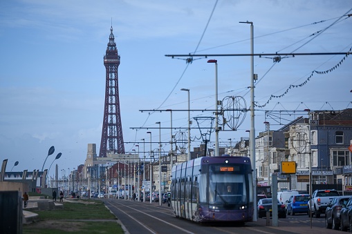 Blackpool, United Kingdom – March 01, 2023: A busy city street near the historic metal tower at sunset in Blackpool, UK