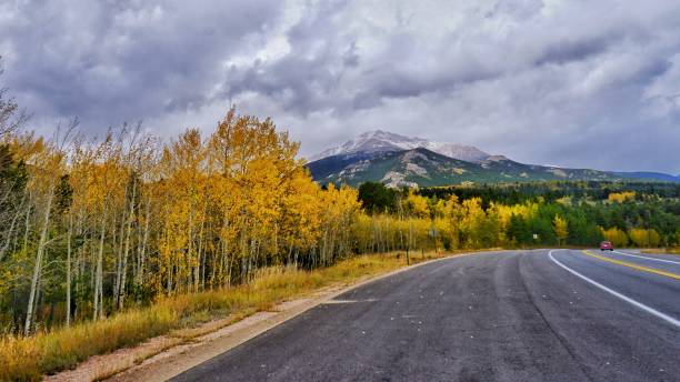 istock Long road winding through a rugged mountain landscape covered in yellow trees 1602750674