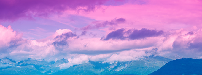 Beautiful purple-pink cloudy sky over mountains at sunset. Sky texture. Abstract nature background