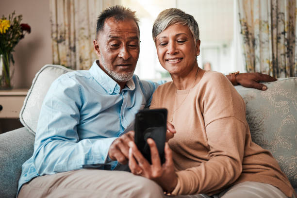 istock Senior couple, phone and reading on home sofa with internet connection, network and love. Mature man and woman relax together on a couch with smartphone for streaming and online news or social media 1602802406
