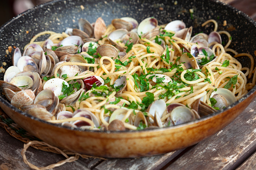 Spaghetti alle vongole in bianco, pasta with clams,served in skillet