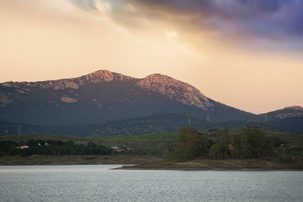 istock Sunset between water and mountain. Beautiful sunset illuminating the clouds 1602840066