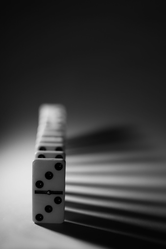 black and white photo with white dominoes with black dots, logic game