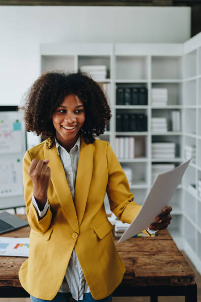 istock American African business woman using document, computer laptop, calculator, paperwork, documents, in winner and smiling Happy to be successful achievement success. finance and investment concepts 1602862633