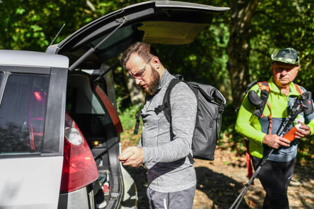 istock Hikers Of Different Ages Picking Up Equipment From Car Trunk 1602865214