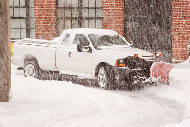 Camion avec une chasse-neige éliminer une route pendant une tempête de neige - Photo