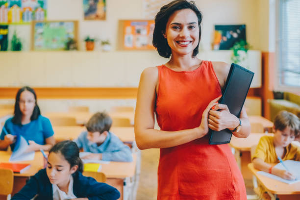 Young teacher in the school building smiling to the camera
