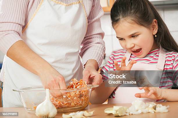 Mother And Daughter Prepare Meat For Lunch Stock Photo - Download Image Now - Assistance, Cheerful, Cooking