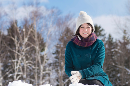 Young Asian woman playing in the snow.