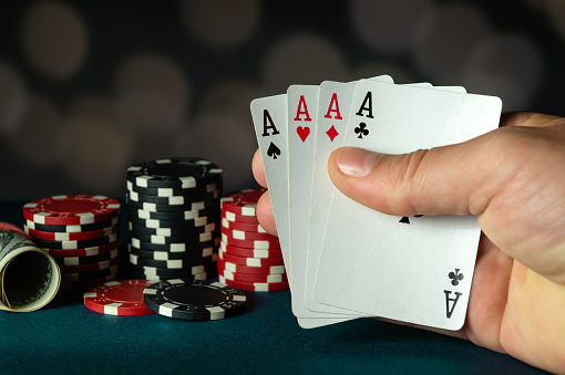 Poker cards with a four of a kind or quads combination in the player hand. Winning combination in a game in a poker club. The concept of luck in the poker game.