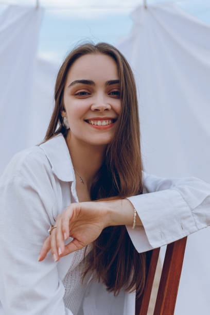 istock Positive woman in white shirt against white sheets 1602973306