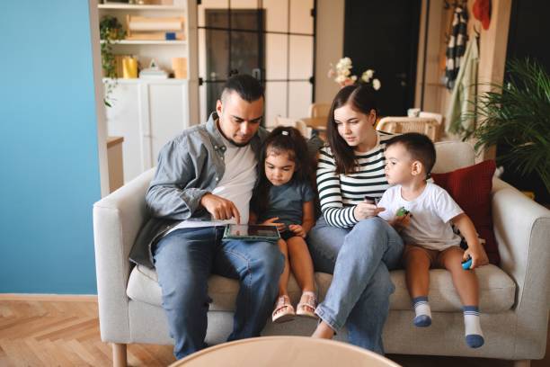 istock Beautiful family sitting at home and using technology 1602973826