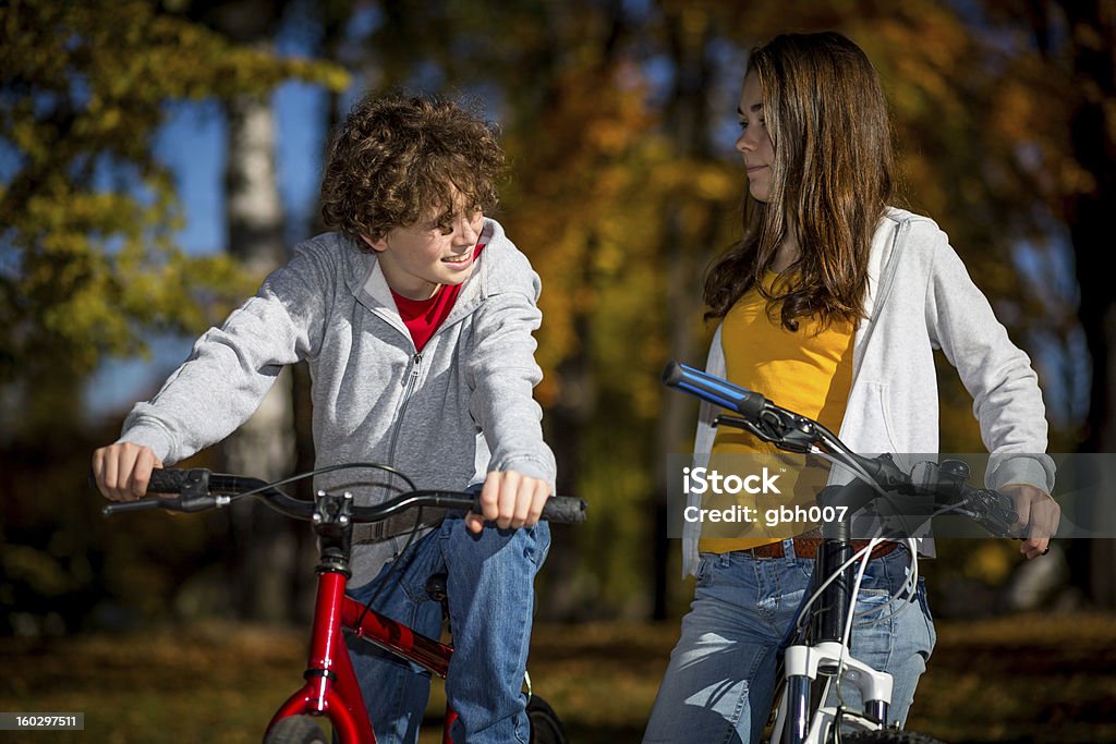 Menina e menino andando de bicicleta no parque da cidade - Foto de stock de 14-15 Anos royalty-free