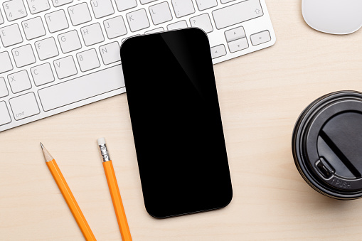 Blank black screen smartphone on a desk, perfect for your design mockup