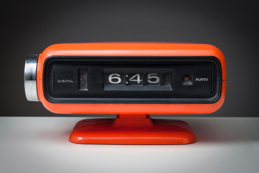 Vintage orange alarm clock on a dark background