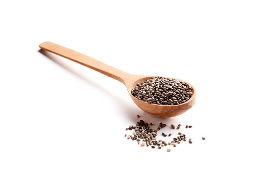 Chia seeds in a wooden spoon isolated on white background