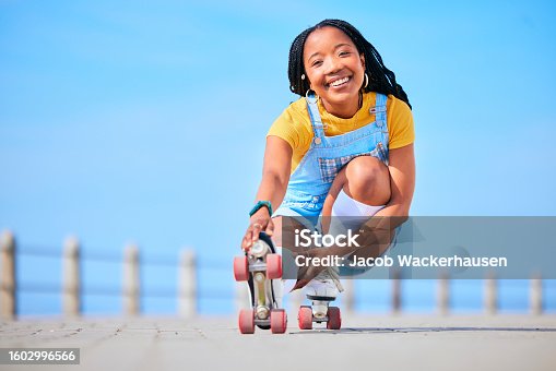 istock Portrait, roller skating and balance with a black woman by the sea, on the promenade for training or recreation. Beach, sport and smile with a happy young teenager in skates on the coast by the ocean 1602996566