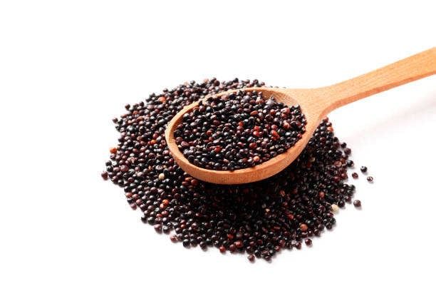 istock Black quinoa in a wooden spoon isolated on white background. 1602998674