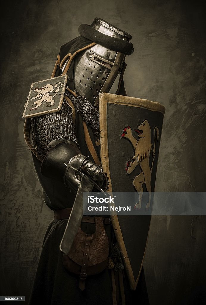 Medieval caballero con espada y protección contra la pared de piedra - Foto de stock de Adulto libre de derechos