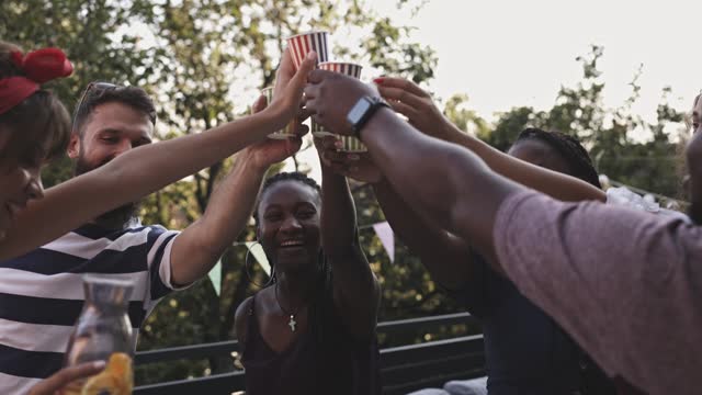 Group of friends cheering with their drinks during a celebratory party