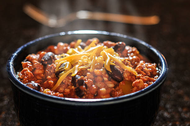 chile con carne con queso en un tazón - guindilla fotografías e imágenes de stock