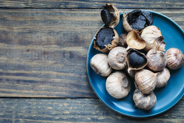 Table top view of black garlic on a wooden table stock photo