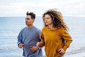 Young Couple Jogging On The Beach In Greece