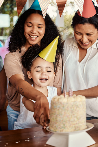 istock Birthday, party and cake for girl with mother and grandmother together for celebrating, bond and fun. Candle, event and child with parents and grandparent at table, happy and excited for celebration 1603021439