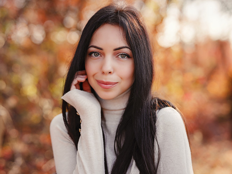 Beautiful young brunette spends her free time in the autumn forest. Embrace life, happiness, joyful habits, mindfulness, health and wellness, empowerment, autumn thinking