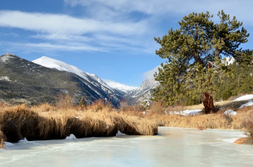 The beautiful Rocky Mountain National Park outside of Estes Park, Colorado in winter with snowcapped mountains in the background.