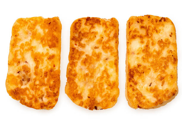 Three fried slices of halloumi cheese with red chilli isolated on white. Top view.