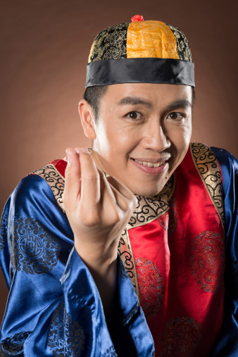 Closeup portrait of Chinese man dress traditional clothes and show funny expression on face.