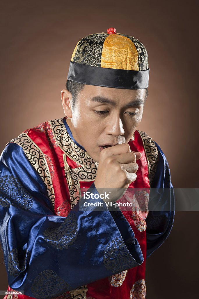 cough Closeup portrait of Chinese man dress traditional clothes and show funny expression on face. Coughing Stock Photo