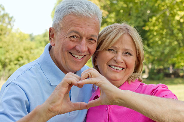 istock Smiling senior couple making a heart with their hands 160307702