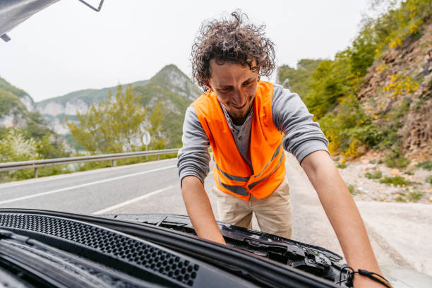 istock Cheerful Young Man Having Car Problems On The Road In The Rain 1603081492