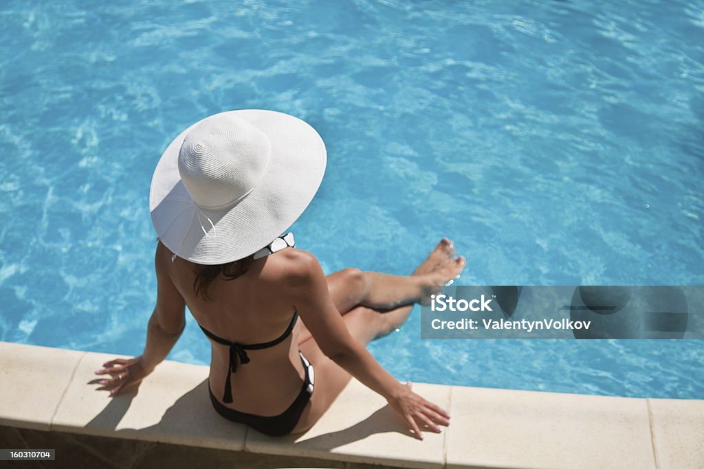 Giovane donna seduta in piscina. - Foto stock royalty-free di Acqua