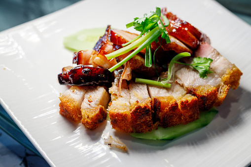 Overhead view of a dish of guinea fowl with pan fried apple and bacon. Colour, horizontal with some copy space, photographed on location at a restaurant on the island of Moen in Denmark.