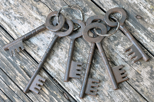 Bunch of old keys close-up on wooden background