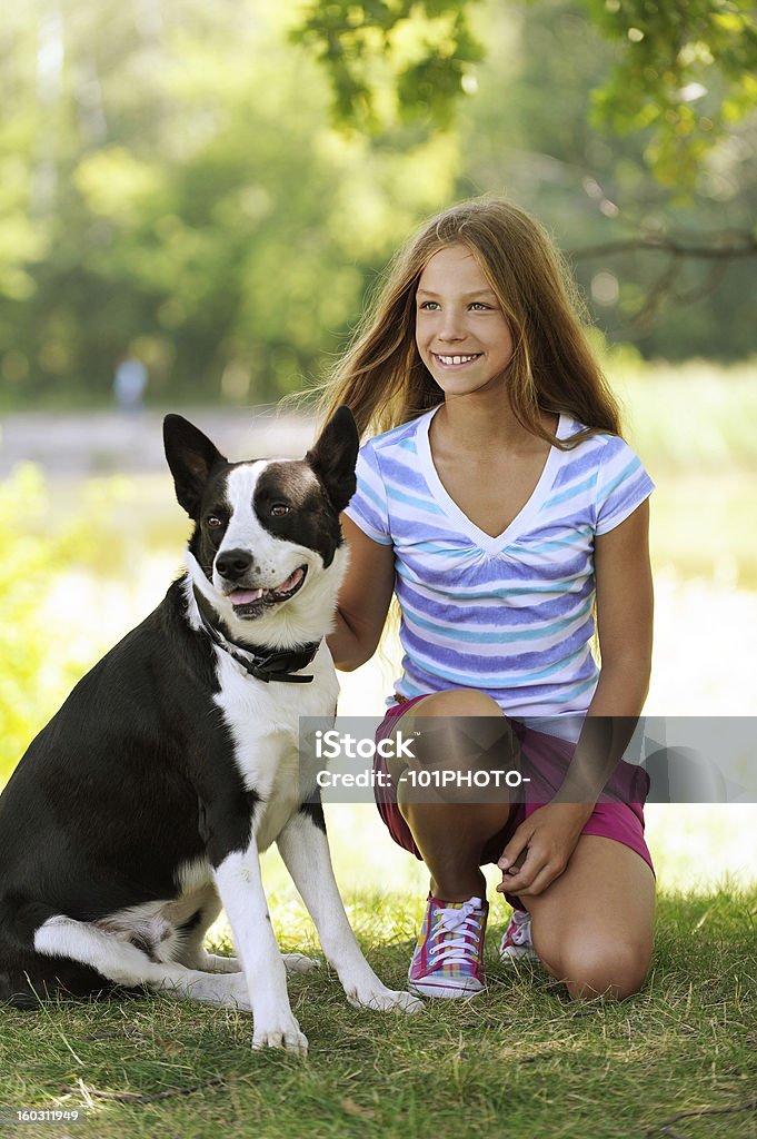 Belle jeune fille souriante avec chien noir - Photo de Adolescence libre de droits